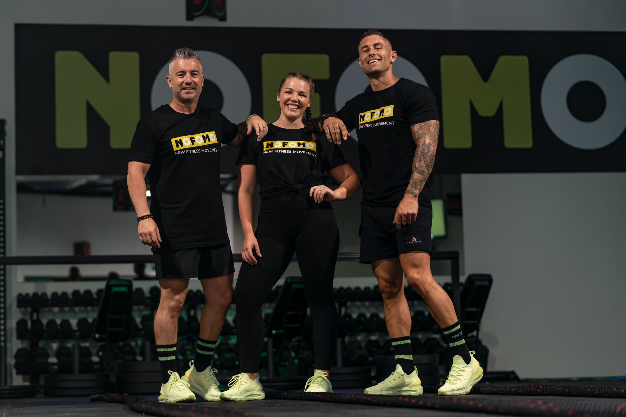 Three people standing next to each other smiling